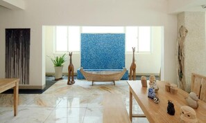 A modern interior with a bathtub, wooden furniture, and decorative items. - Qixingtan Hai Wan (Xincheng)