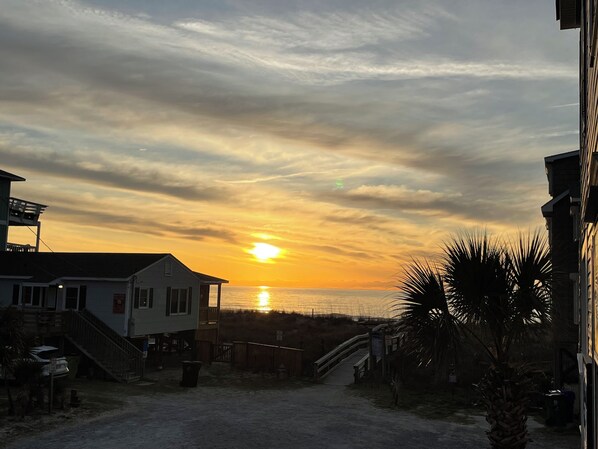 A coastal building with a view of the sunset over the ocean. - Pet friendly Leeward Cottage: Only a Few Steps to the Beach (Carolina Beach)