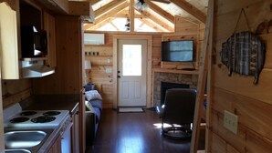 Interior de una cabaña de madera con cocina, comedor y sala de estar.