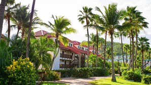 Ein Resort mit mehrstöckigen Gebäuden, Palmen und einem gepflegten Garten.