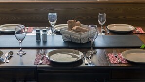 A dining table set with plates, cutlery, glasses, and a bread basket. - Large beautiful Farmhouse in the heart of PEC - 20 minutes to Sandbanks (Prince Edward)