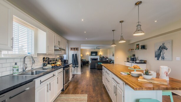 A modern kitchen with stainless steel appliances, a wooden countertop, and pendant lighting. - Large beautiful Farmhouse in the heart of PEC - 20 minutes to Sandbanks (Prince Edward)