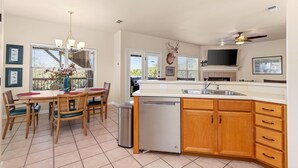 A spacious kitchen with wooden cabinets, a dishwasher, and a large island with a sink. - Spacious Ranch Lake Retreat Hot Tub, Tesla Charger (Canyon Lake)