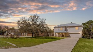 A two-story house with a garage, a front yard, and a driveway. - Spacious Ranch Lake Retreat Hot Tub, Tesla Charger (Canyon Lake)