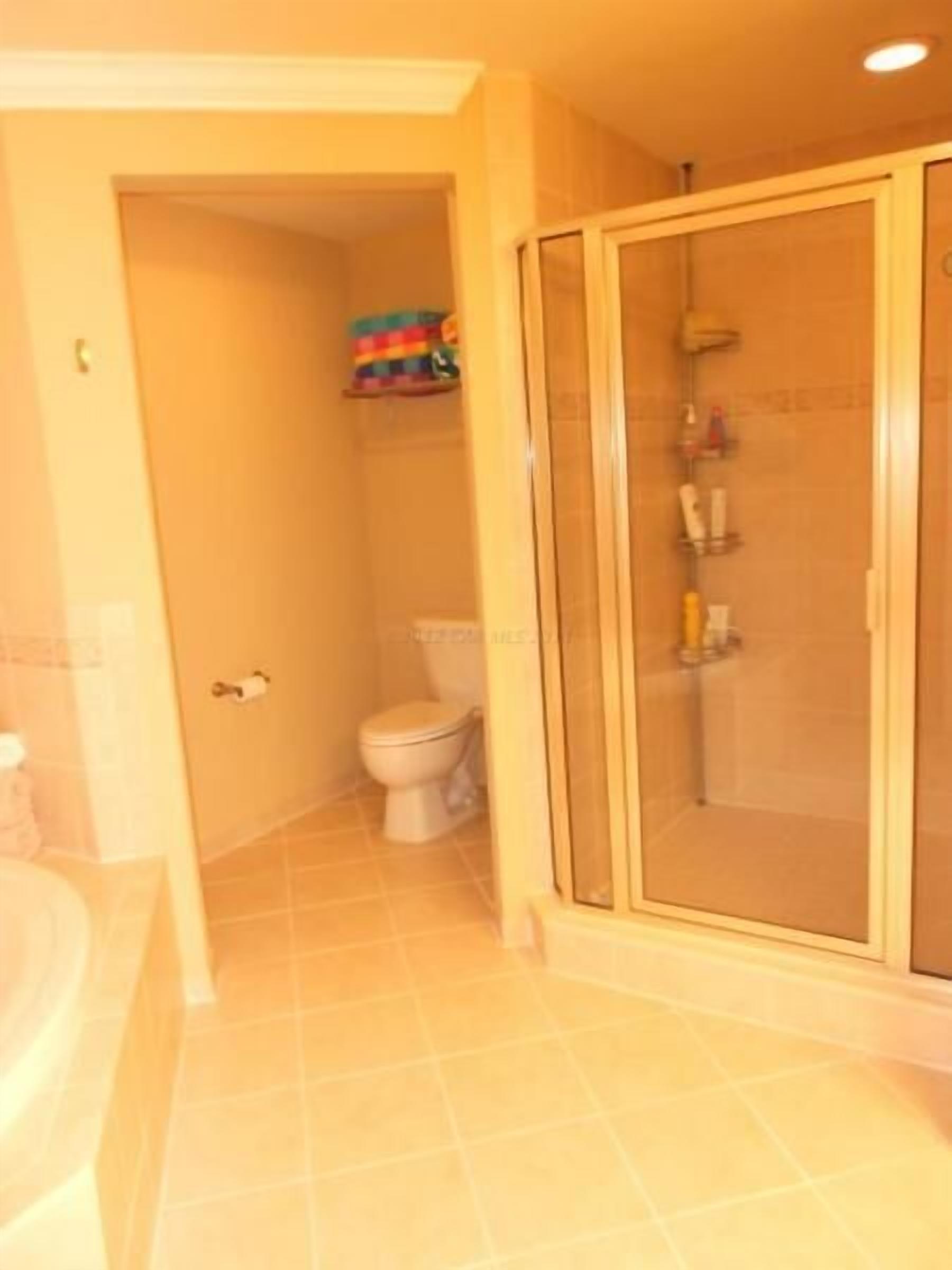 Un bagno con un water, box doccia e vasca da bagno.