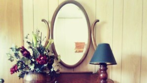 Un comò in legno con quattro cassetti, uno specchio e una lampada.
