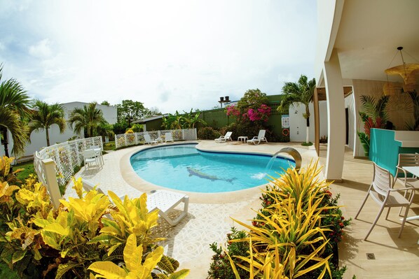 Een buitenzwembad, parasols voor strand/zwembad