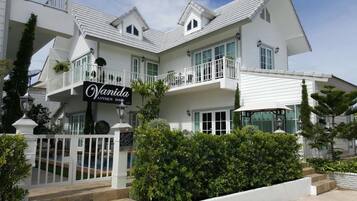 Una casa grande y blanca de varios pisos, con un letrero que dice 'Vanida Antique Home'.