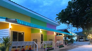 Un edificio colorido con un porche, escalones y macetas.