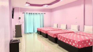 Habitación de hotel con dos camas, un escritorio, un cubo de basura y una ventana con cortinas.