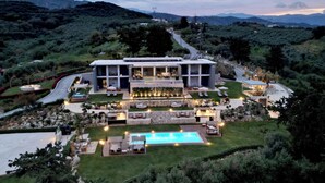A modern villa with a swimming pool, outdoor seating, and a landscaped garden. - 9 beds, 7 wc, sauna, jacuzzi, pool, cinema, bar, bbq, firepit, helipad, parking (Chania)