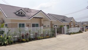 A residential building with a tiled roof, a white picket fence, and a gated entrance. - Sandy Home Sattahip (Sattahip)