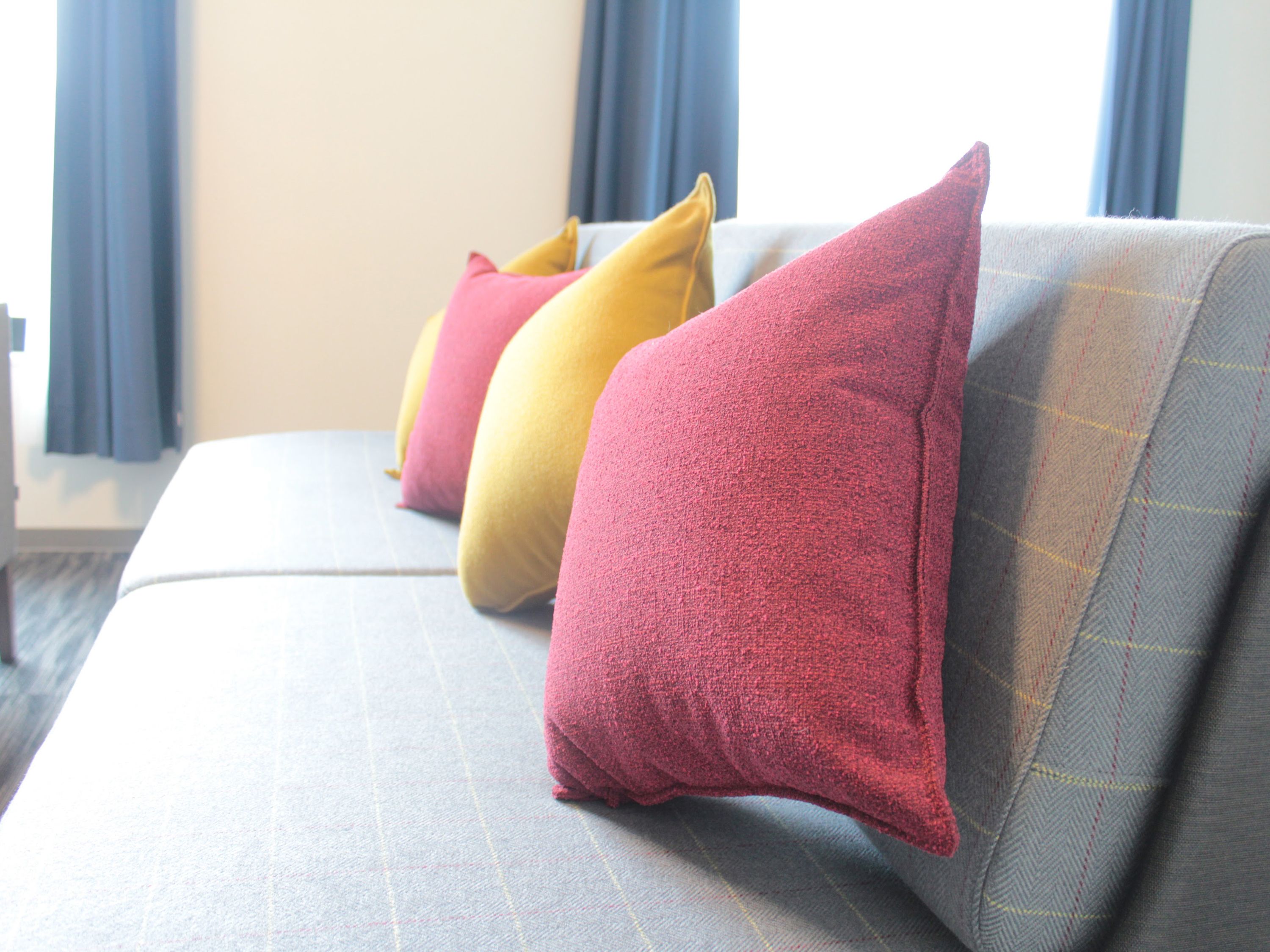 Un sofá con tres almohadones de distintos colores.