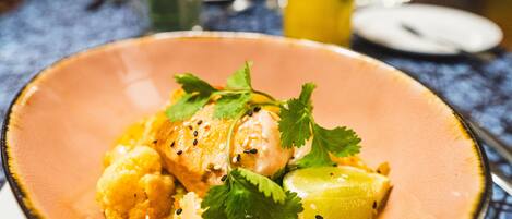 A plate of food with a creamy sauce, garnished with cilantro and sesame seeds.