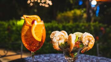 Two drinks on a table with a blurred outdoor background.