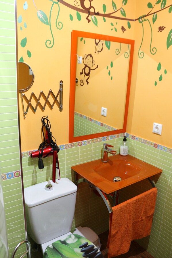 Un baño con inodoro, lavamanos y espejo.