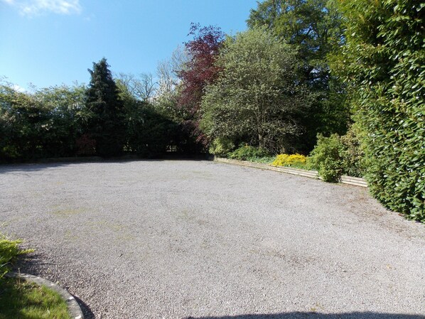 A gravel parking area with a curved driveway leading to a building. - Charming, historic mill close to the Cotswold Way in North Nibley<br> (North Nibley)