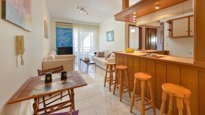 Una cucina moderna con sgabelli da bar in legno, un tavolo da pranzo con sedie e un angolo bar.
