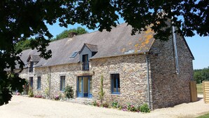 A stone building with multiple windows and a sloped roof. - Beautiful stone gite in rural Brittany (Ruffiac)