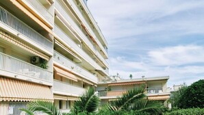 Een meerlaags woongebouw met balkons, een plat dak en een heldere lucht.