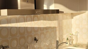 Een moderne keuken met een inbouwfornuis, spoelbak en witte kastjes.