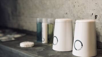 Three white containers with a circular logo on a concrete surface.
