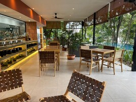 Restaurante moderno com mobiliário de madeira e uma vitrine de vidro.