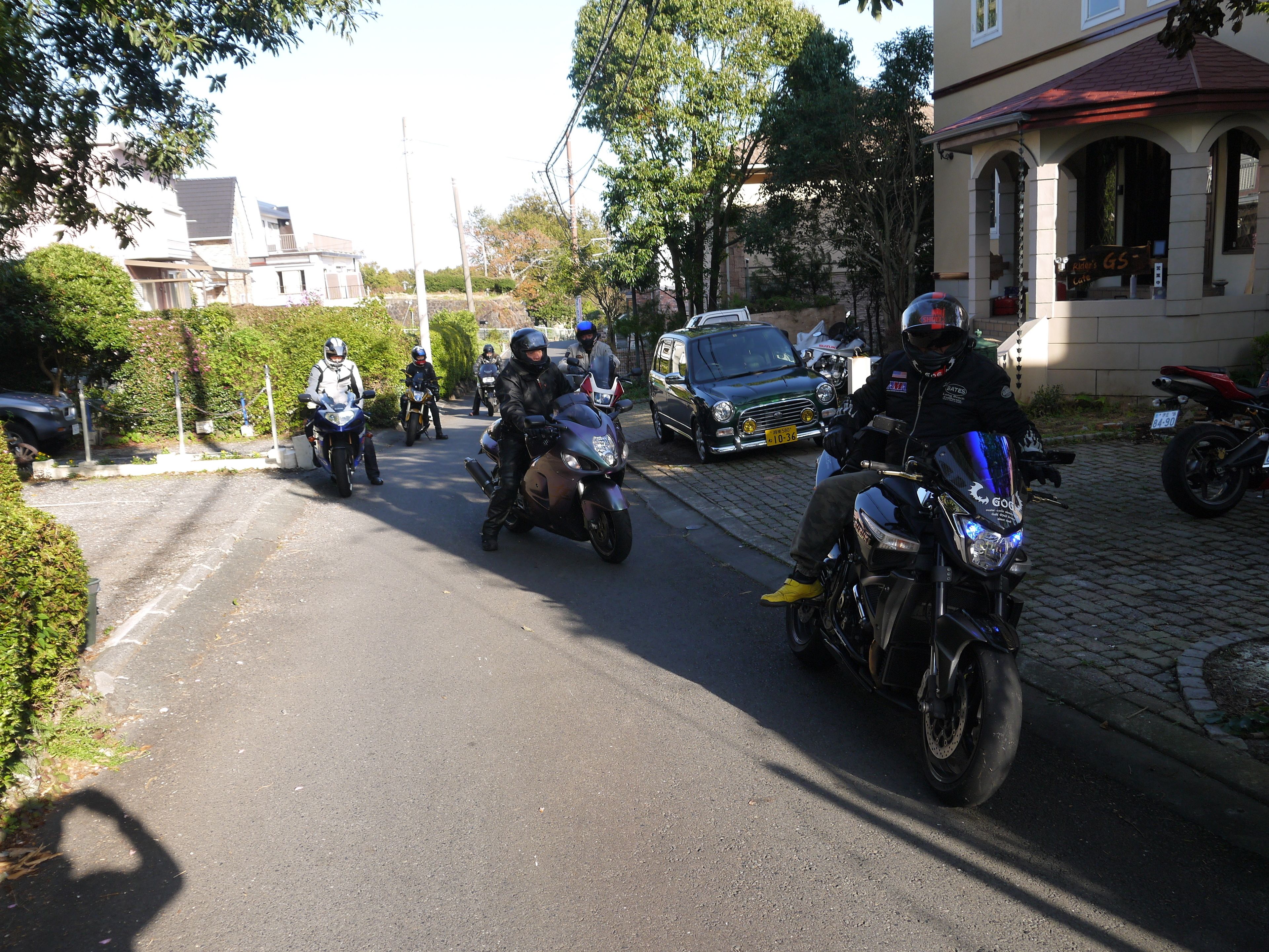 A group of motorcyclists on a residential street.
