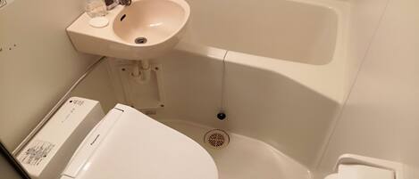A bathroom with a toilet, sink, and bathtub.