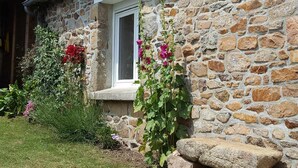 A stone house with a window, a satellite dish, and a stone bench. - Sea view, comfortable house in Loguivy-de-la-Mer, near Paimpol  (Ploubazlanec)