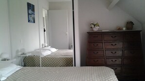 Un dormitorio con cama, cómoda y espejo.
