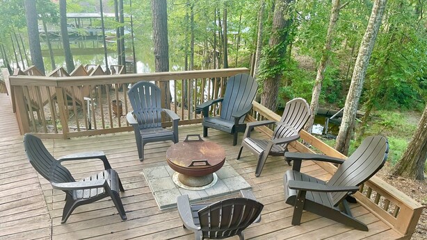 Puinen terassi, jossa on Adirondack-tyyliset puutarhatuolit ja keskellä avotakka.