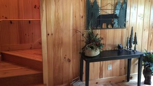 A wooden interior with a black table, a decorative metal piece, and a small plant. - Beautiful Creekside Cabin 3 Bedroom Robbinsville, NC Perfect Family Location! (Robbinsville)