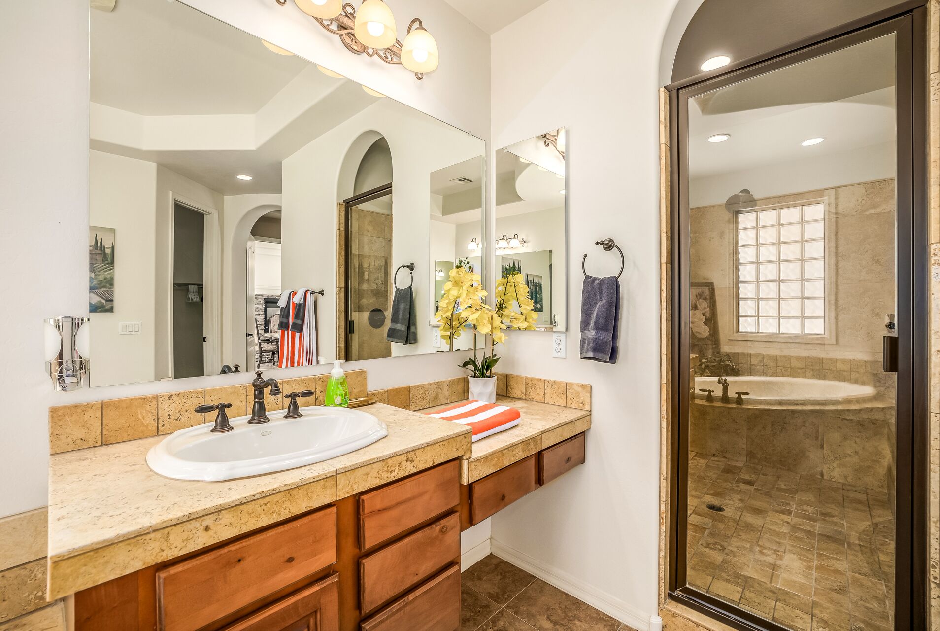 Une salle de bain moderne avec un grand miroir, un lavabo et une douche.