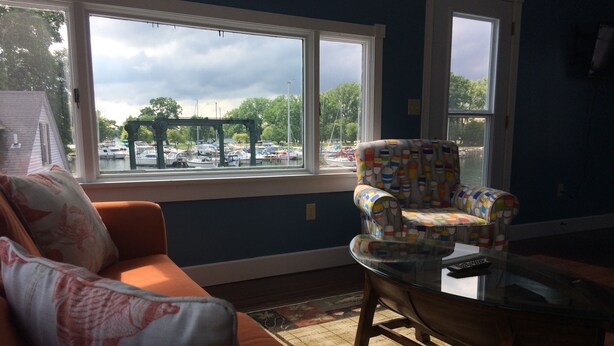 A living room with a large window, a sofa, a patterned armchair, and a glass coffee table. - Amazing view of Seneca Lake, close to wine trail and water activities (Geneva)