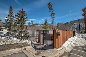 A gated entrance with a sign indicating the hot tub closes at 10:00 PM.