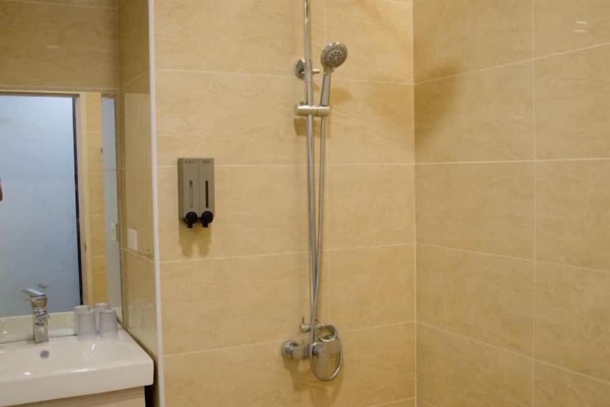 A bathroom with a shower, a sink, and a mirror.