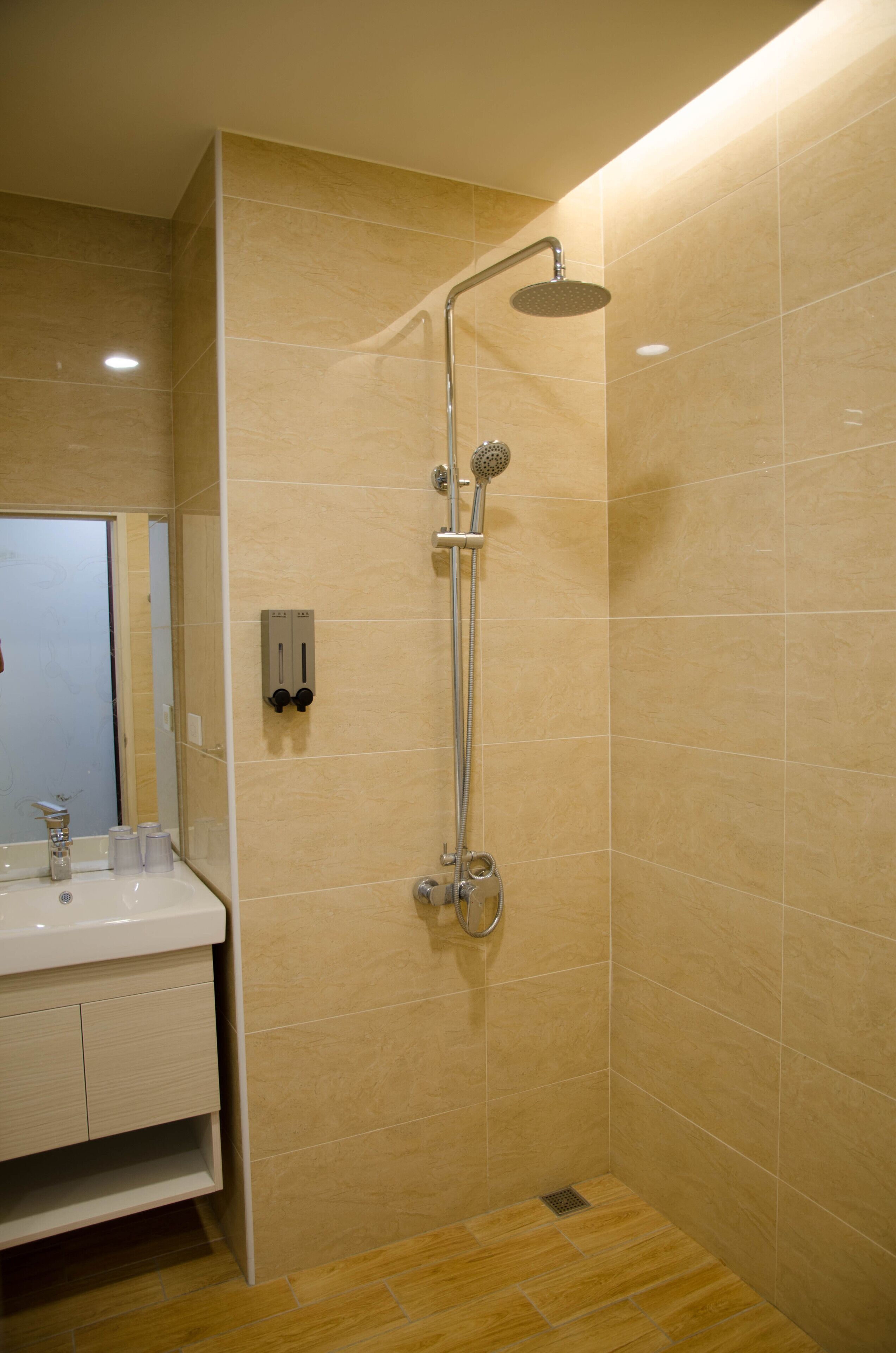 A modern bathroom with a shower, a sink, and a mirror.