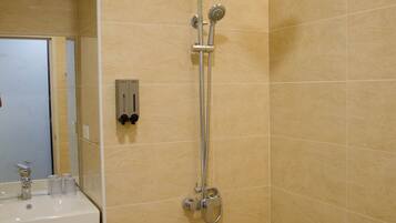 A modern bathroom with a shower, a sink, and a mirror.
