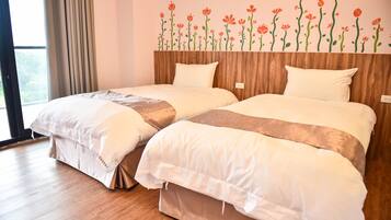 Habitación de hotel con dos camas y cabeceros de madera, además de un adhesivo floral en la pared.