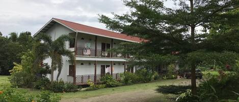 A two-story building with a red roof and a balcony.