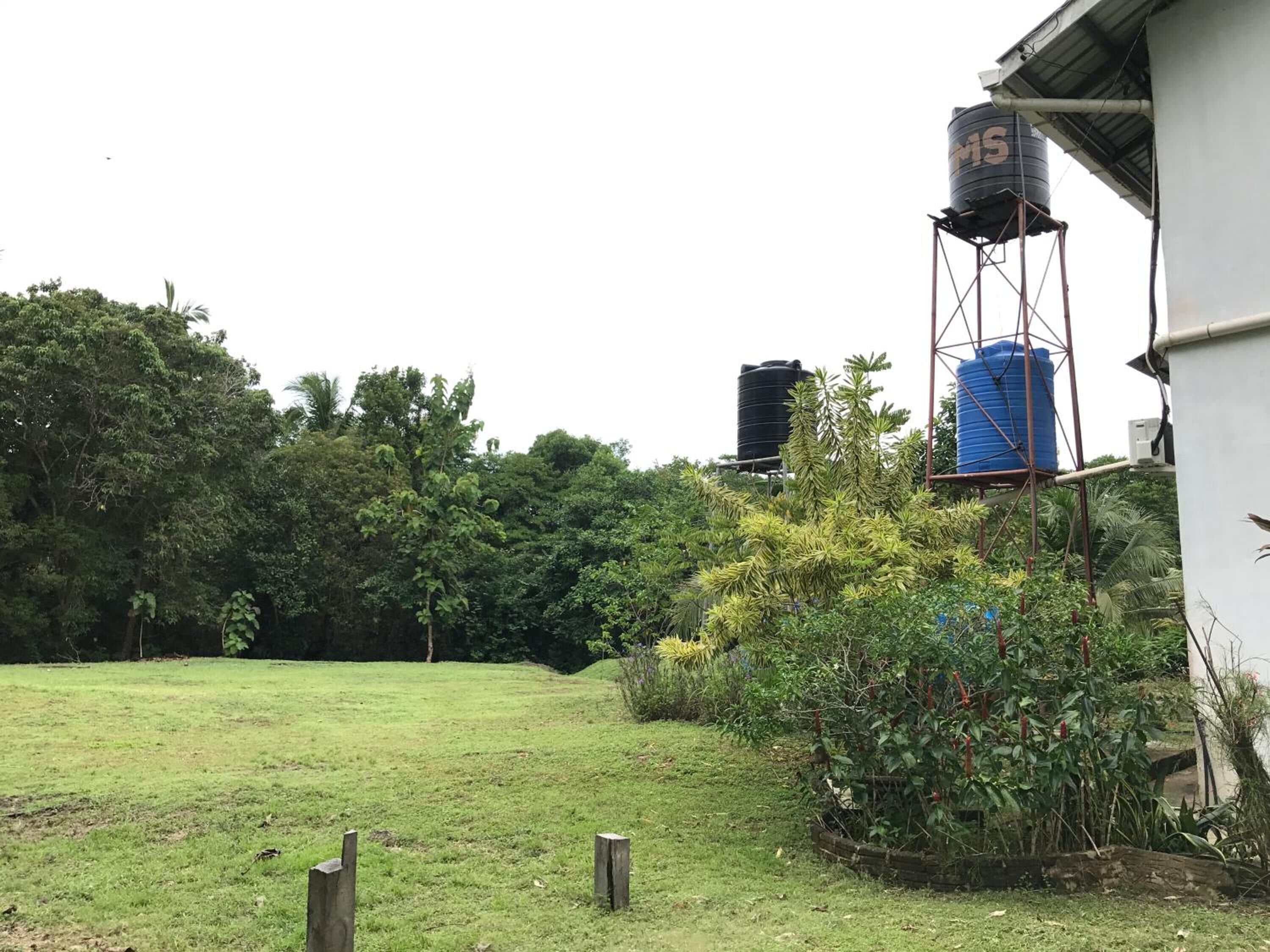 A grassy area with a water tank on a metal structure.