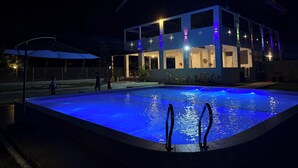 A modern building with a swimming pool at night, illuminated by blue lights. - RTMS Guesthouse Semporna (Semporna)