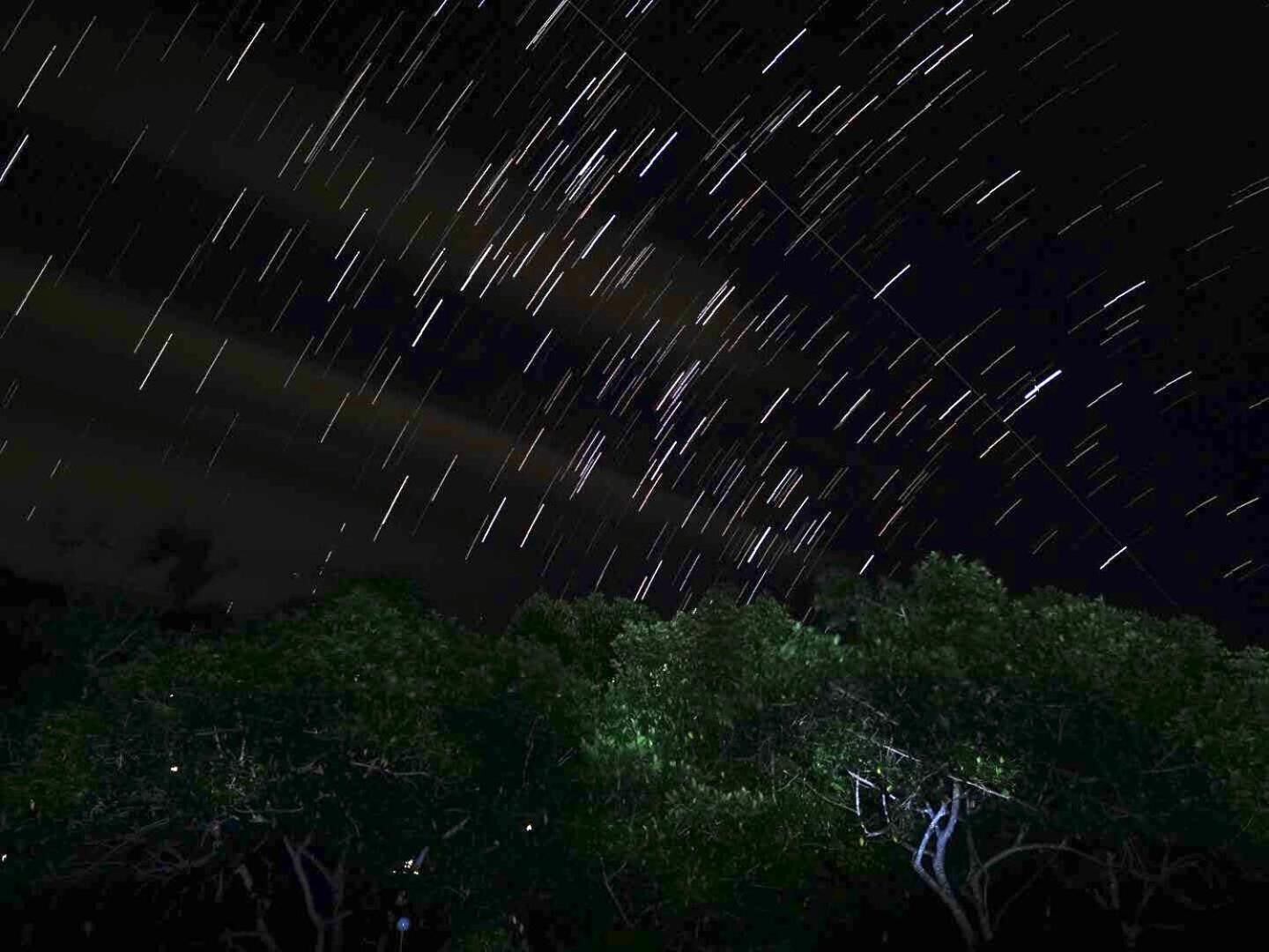 A starry night sky with visible star trails.