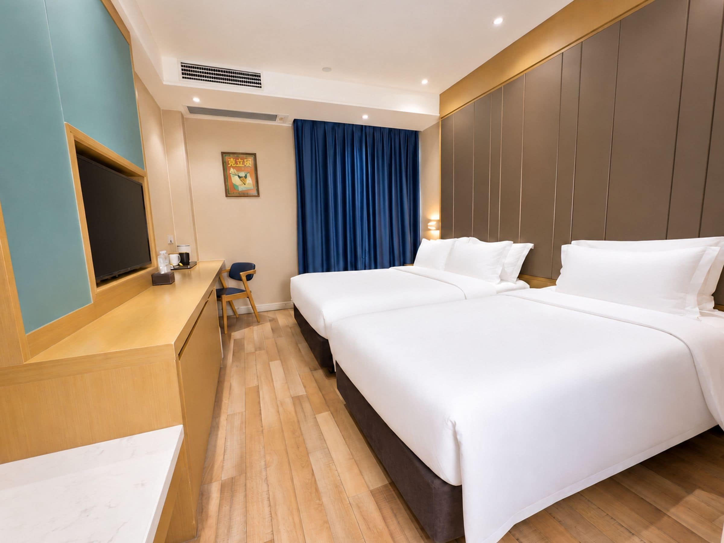 Une chambre d’hôtel équipée d’un lit, d’un bureau, d’une chaise, d’un téléviseur et d’une œuvre d’art accrochée au mur.