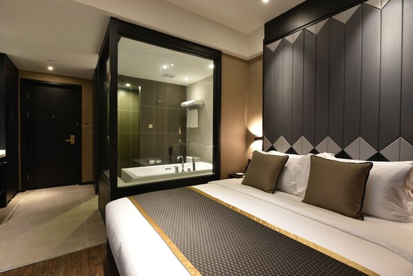 A modern hotel room with a large bed, a glass-enclosed bathroom, and a dark wood headboard. - SHANGHAI-DECO Hotel (Shanghai)