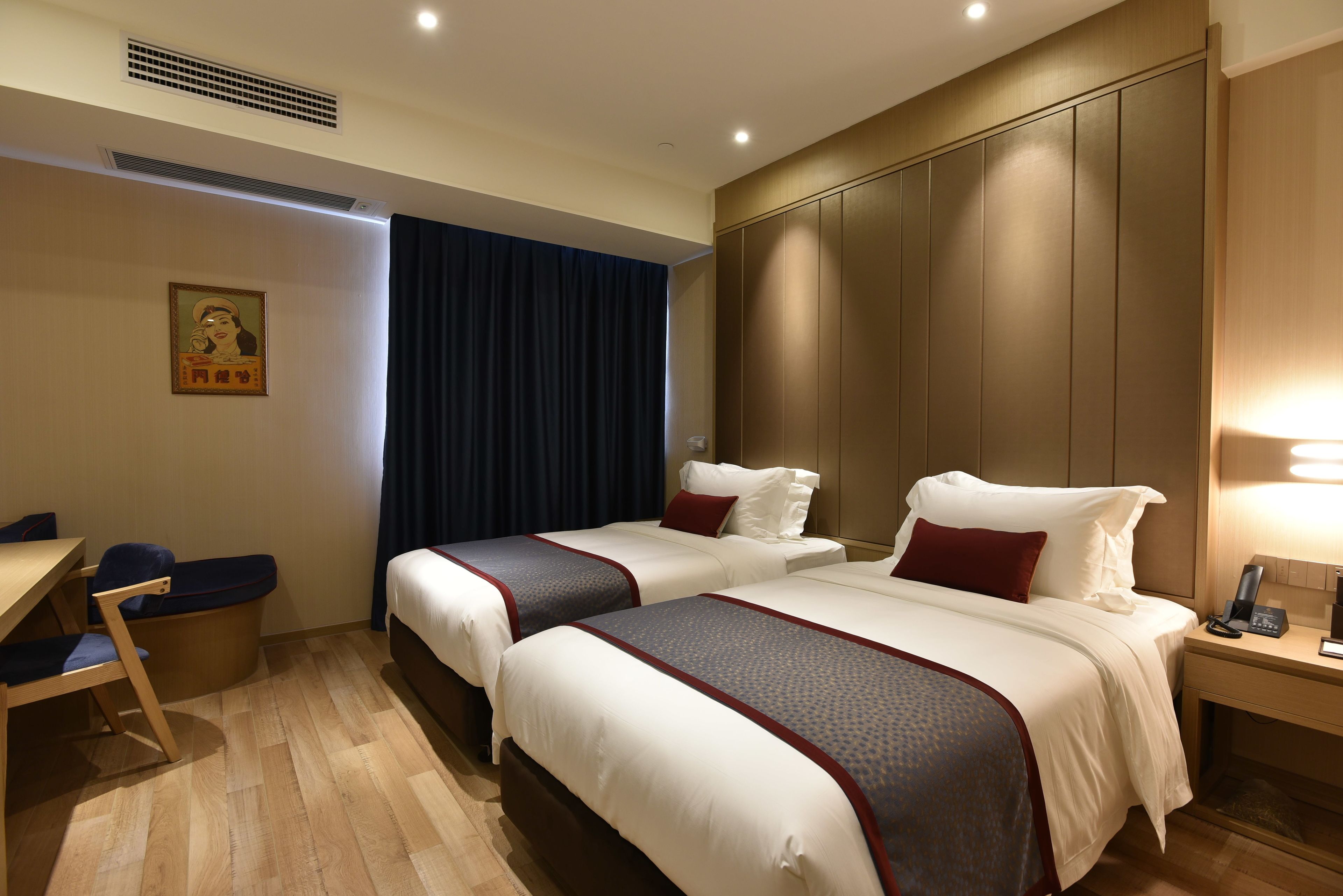 Habitación de hotel con dos camas, un escritorio y una silla.