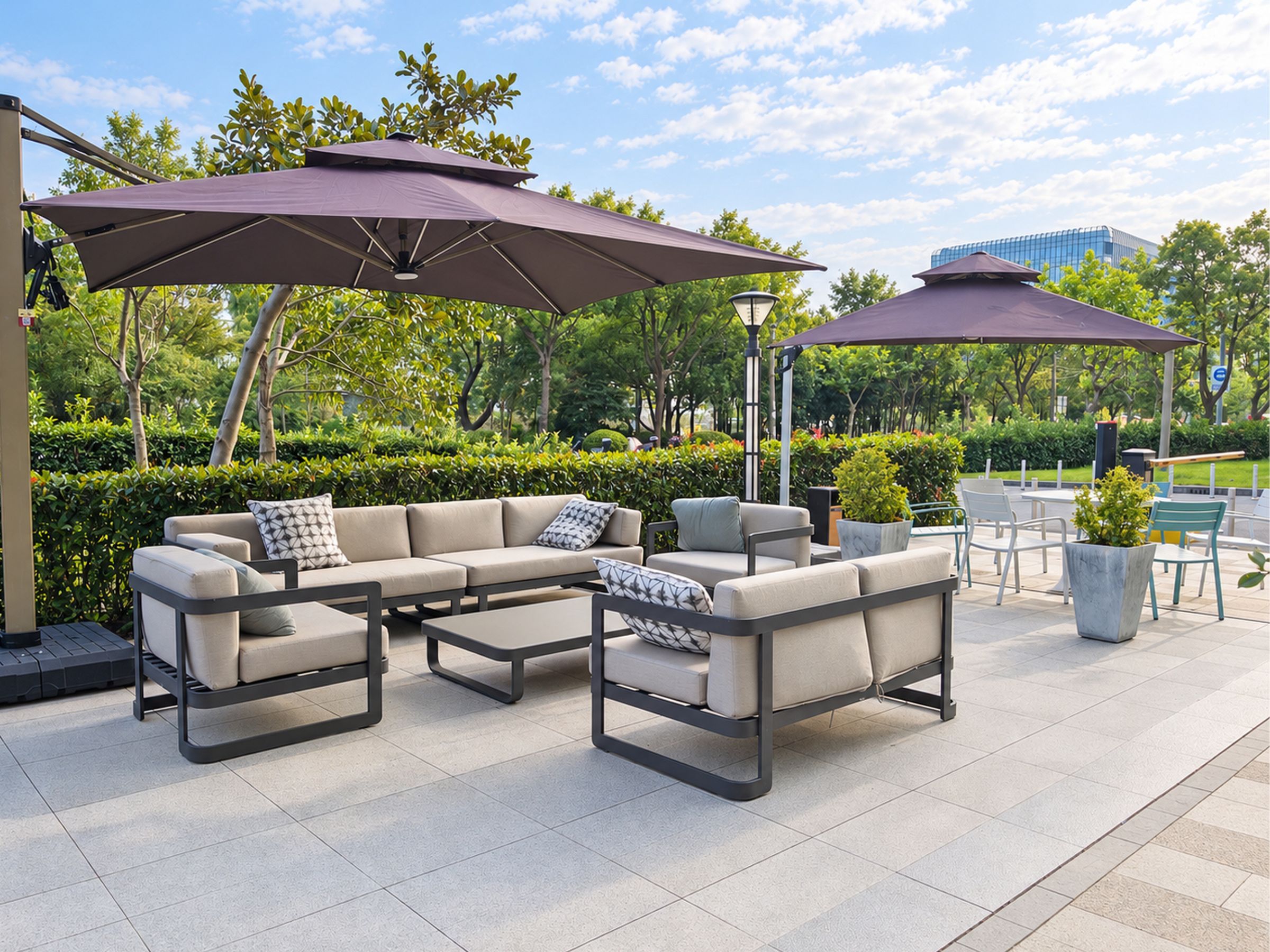 An outdoor patio area with a sectional sofa, two umbrellas, and a dining table with chairs.
