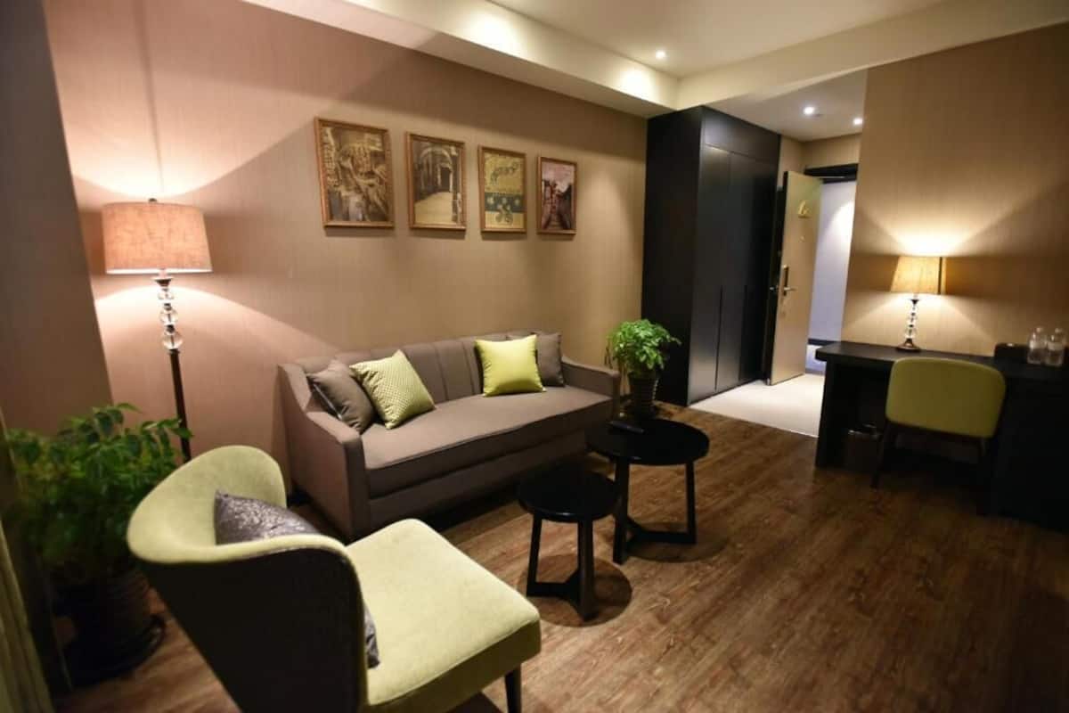 A modern living room with a sofa, armchairs, a coffee table, and a desk area.