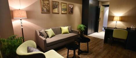 Una sala de estar moderna con un sofá, sillones, una mesa de centro y una zona de escritorio.